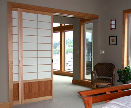 Shoji screens that slide into a wall pocket built in at the framing stage of this project.