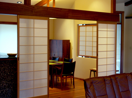 A row of sliding shoji screens separates the kitchen / dining room from the living room.