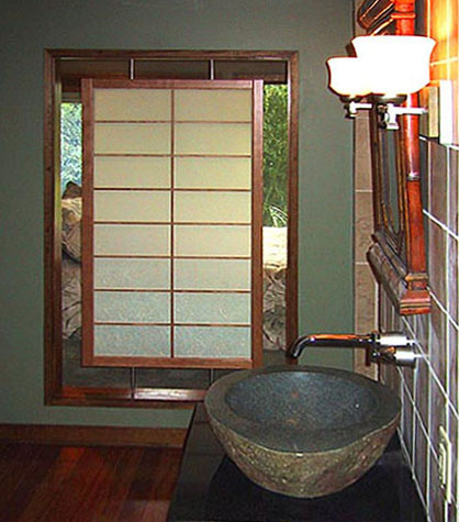 A shoji screen suspended in a wall opening between the master bath and bedroom using metal supports.
