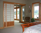 Pocket door shoji screen room dividers separate the master bedroom from the living area